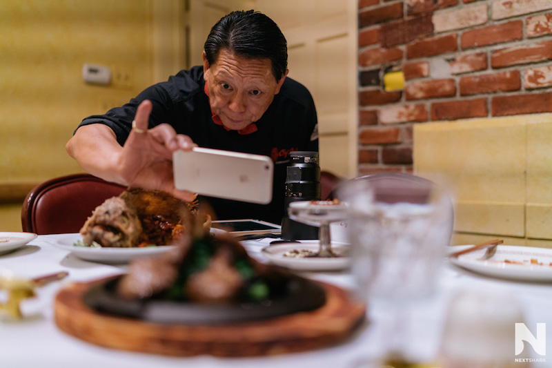 Chef Lawrence Chu photographing a dish with his phone