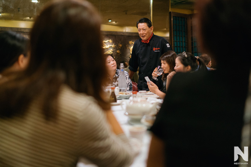 Chef Lawrence Chu speaking with guests at a restaurant table