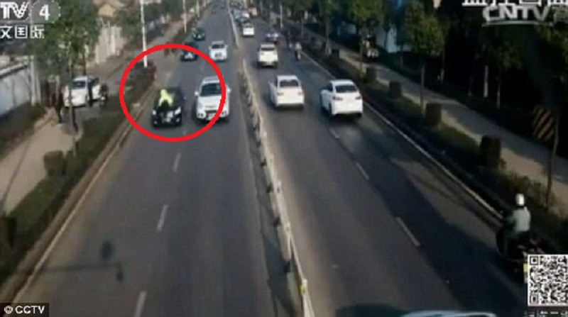 Badass Chinese Policeman Jumps on Car As It Speeds Away