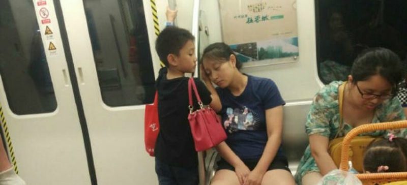 Boy Lets Exhausted Mother Use His Hand as a Pillow on Subway in China