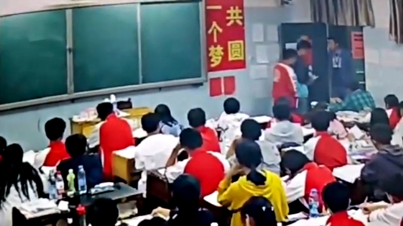 A middle school teacher in southern China has been suspended after assaulting two male students in front of the class.