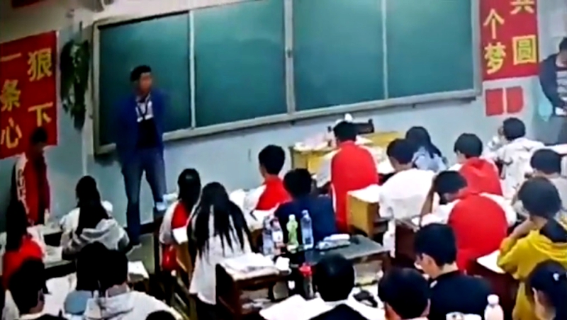 A middle school teacher in southern China has been suspended after assaulting two male students in front of the class.