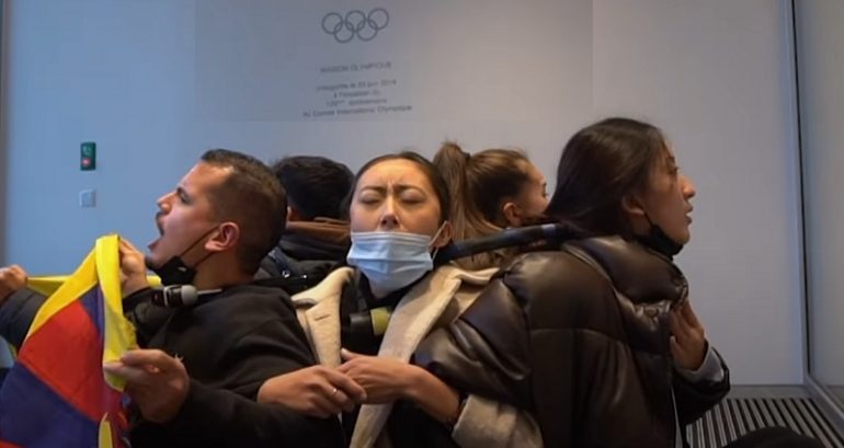 Tibetan students chain themselves to Olympics logo in front of IOC to protest Beijing 2022