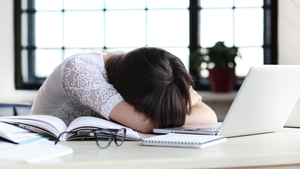 Woman laying her head down on her desk