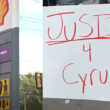Shell gas station sign, protestor sign that reads "JUSTICE 4 Cyrus!"