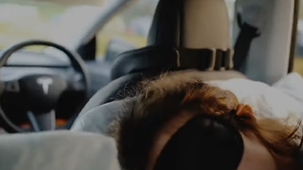 A person sleeping in a Tesla