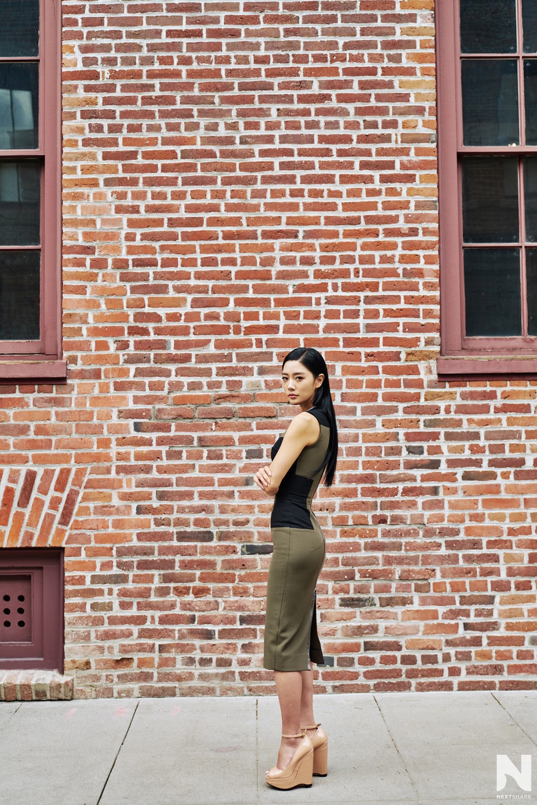 Full-length portrait of Clara Lee in front of a brick building